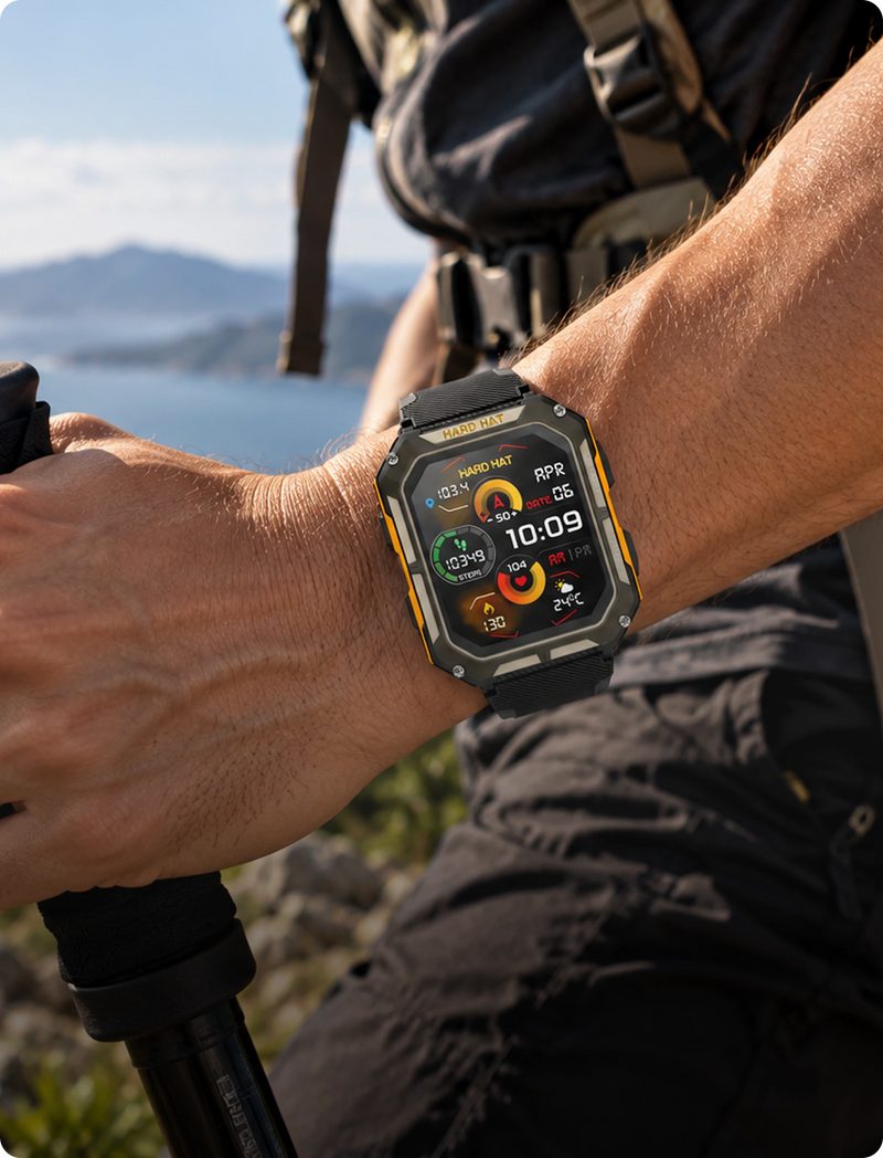 A rugged smartwatch with a black and yellow protective case worn on a person's wrist, shown outdoors with a mountain and lake in the background.